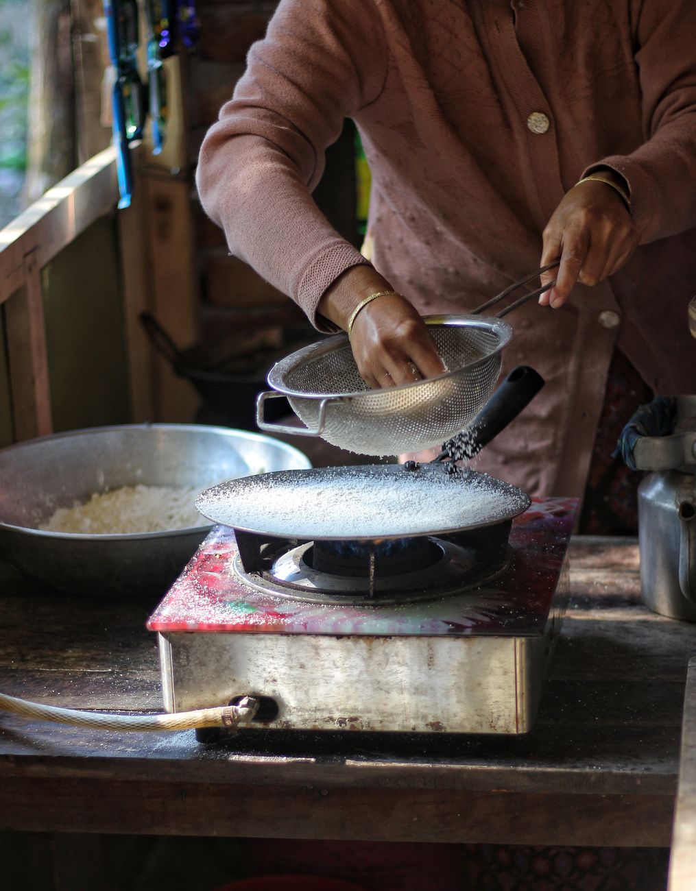 Cocinera trabajando en el metate de piedra volcánica